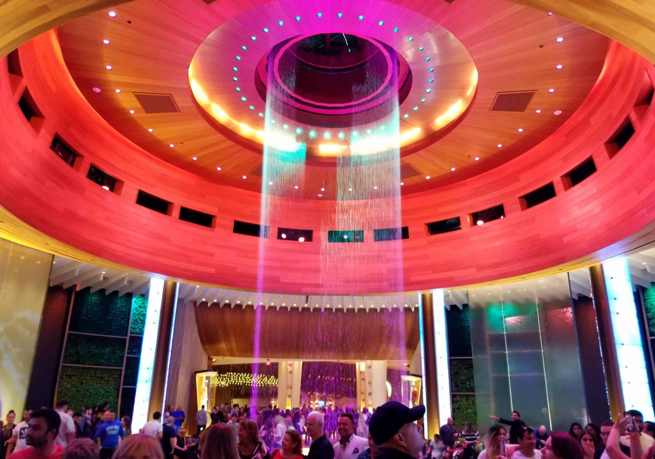 Hollywood, Florida, U.S.A - January 2, 2020 - Crowds by the colorful water fountain inside of Seminole Hard Rock Cafe and Casino Hard rock hotel & casino hologram